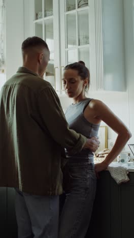 una pareja abrazándose en la cocina.