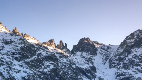 sunset at laguna grande de gredos, perfect reflection of the mountains in the half frozen lake