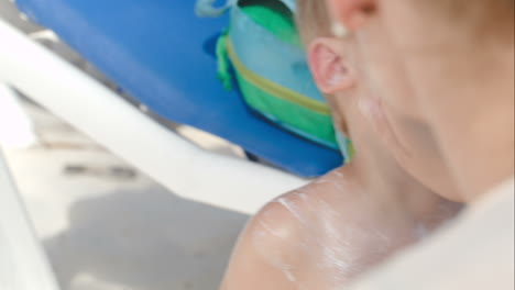 mother and son having fun while applying suntan lotion