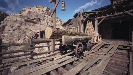 log cart on rustic wooden bridge near old western town under bright sky