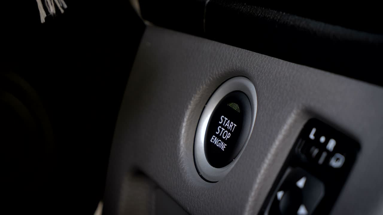 foto de cerca de la mano de la mujer presionando el botón de arranque del motor para encender el coche