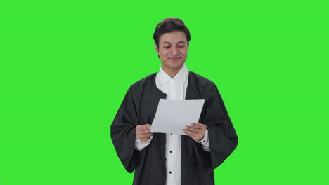 abogado indio feliz leyendo contratos pantalla verde