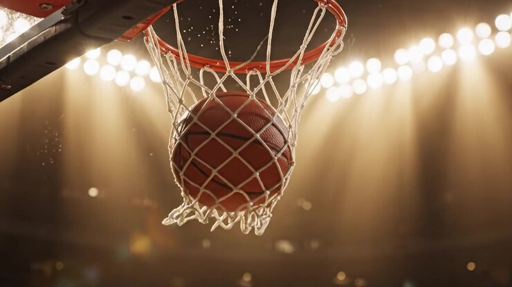 Momenti drammatici nel basket: catturando l'essenza dello sport al suo apice con una vista dinamica del canestro e della palla mentre l'azione si svolge sotto le luci brillanti.