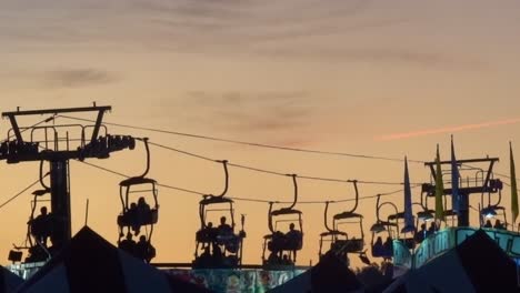 Setting-sun-silhouettes-the-sky-tram-ride-at-the-North-Carolina-State-Fair-in-Raleigh,-NC,-2019