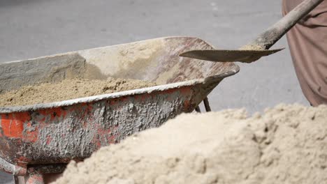 construction wheelbarrow with sand and concrete mixture