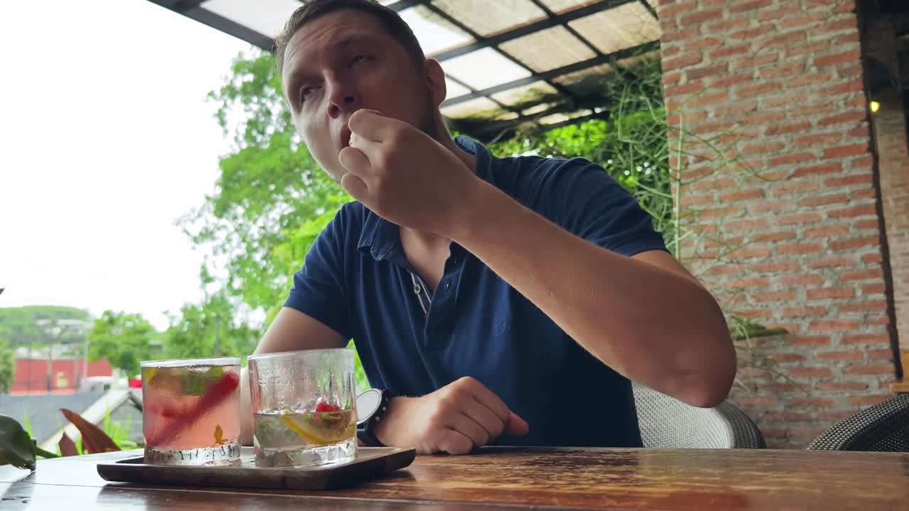 hombre comiendo fresa y bebiendo cócteles