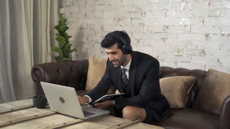 smiling middle east business man, ceo person working from home, writing a business graph document or a report with computer notebook laptop device in technology concept.