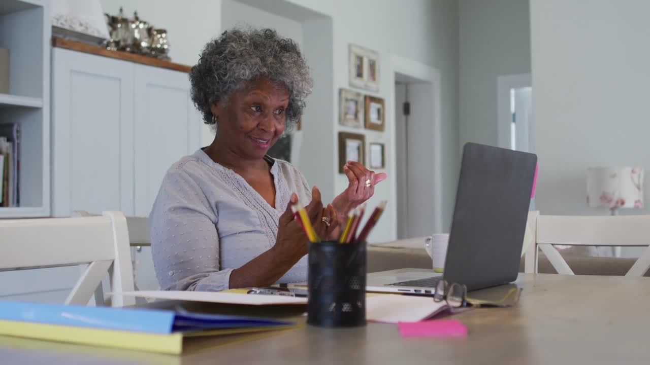 Senior african american woman having a video chat on laptop at home