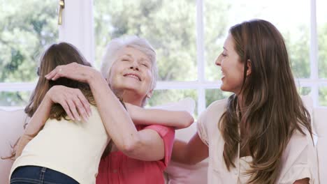 girl embracing grandmother on the sofa