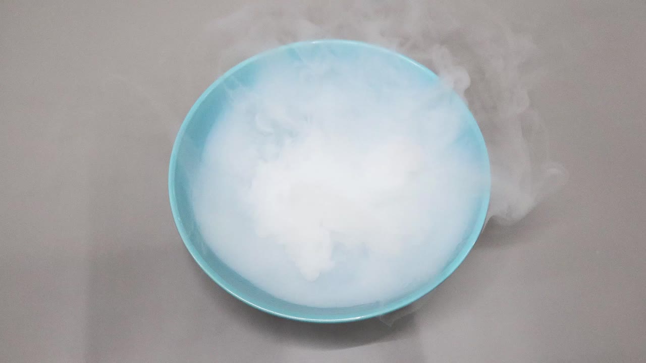 hielo seco reaccionando y sublimando en agua azul