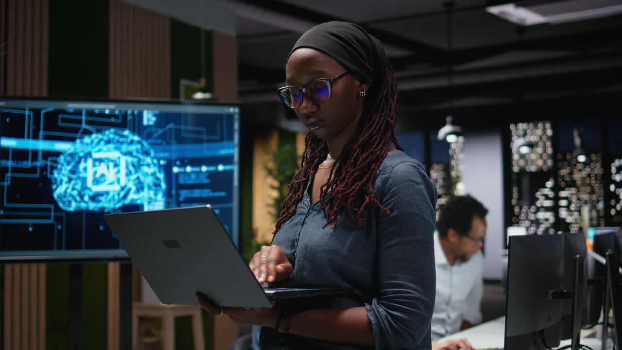 African American Woman Working on Laptop in Modern Tech Office