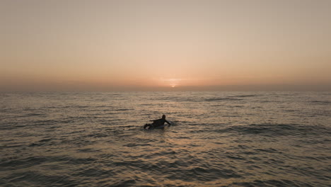 surfer-girl-paddling-across-the-atlantic-ocean-into-sunrise-on-fuerteventura-Canary-Islands