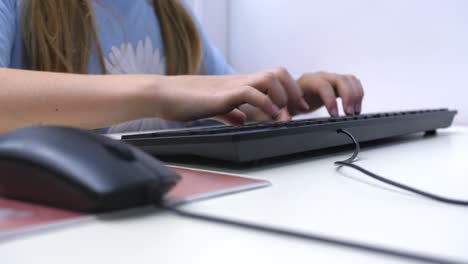 young girl learning to use computer, hand goes from mouse to keyboard, defocus slow motion