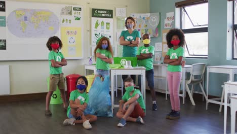 maestra y un grupo de niños que usan una camiseta con símbolo de reciclaje en la clase