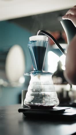hand pouring hot water for drip coffee process