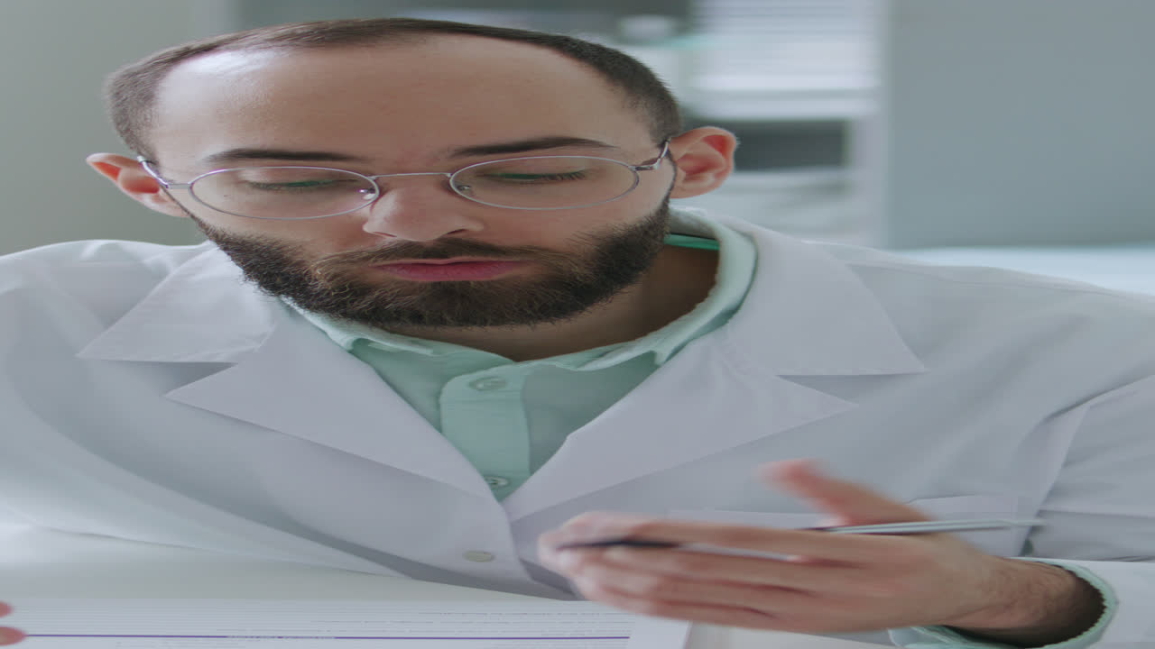 Bearded Male Doctor Talking to Patient during Medical Appointment