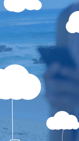 animation of clouds with electronic devices over caucasian woman using smartphone