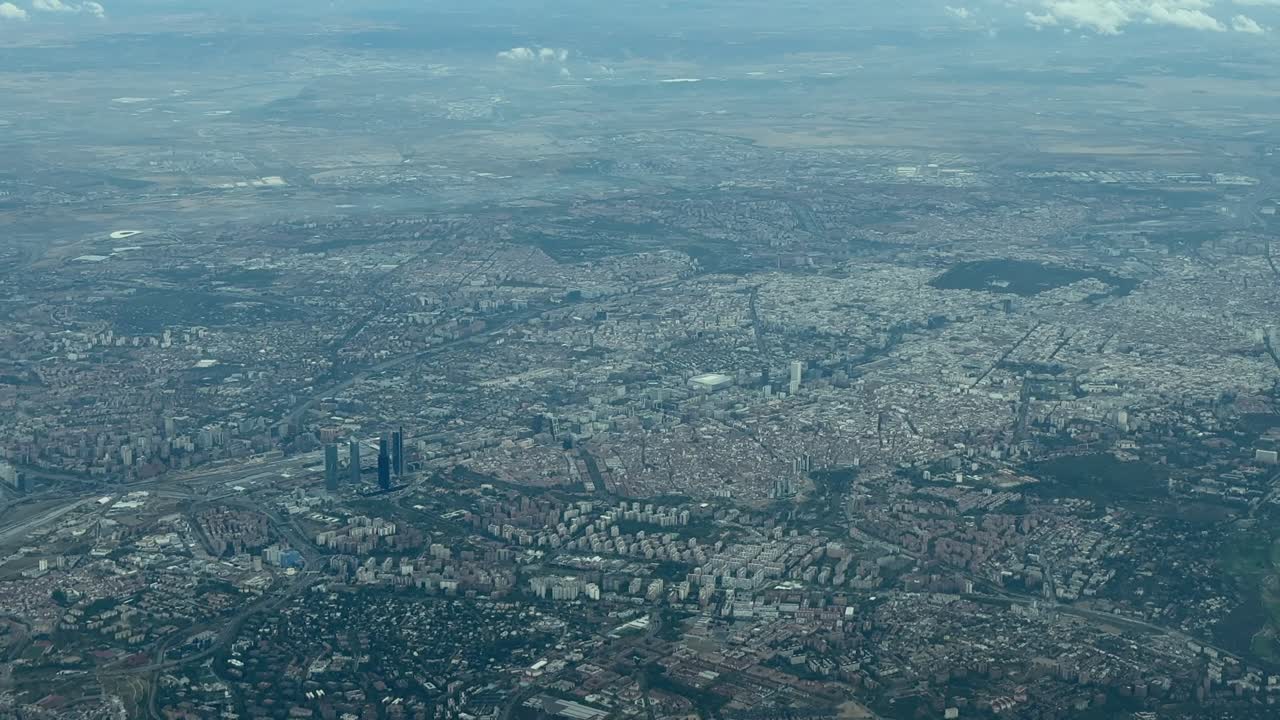 An alevated left side aerial view of Madrid city early in the morning, taken from a plane cokpit. handheld camera shot