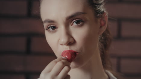 mujer sexy comiendo fresas maduras en la cámara. chica sensual comiendo fresas