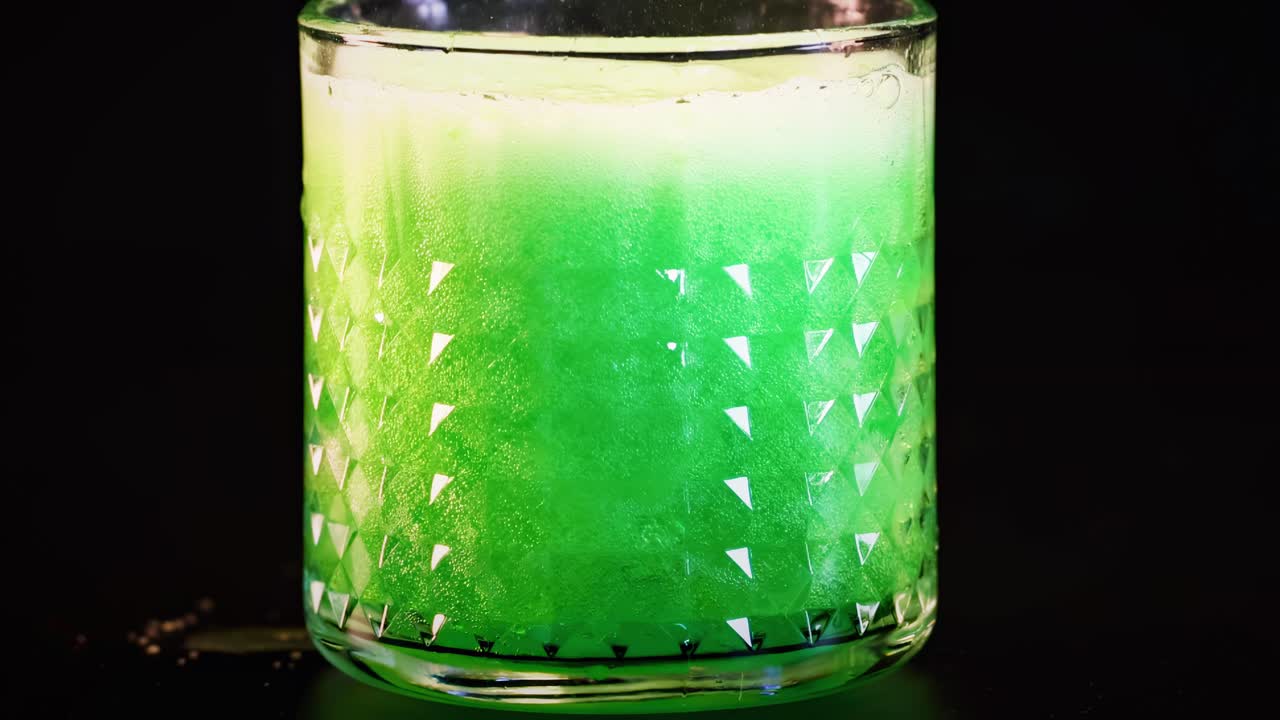 녹색 음료가 유리잔에 여 거품을 형성합니다.