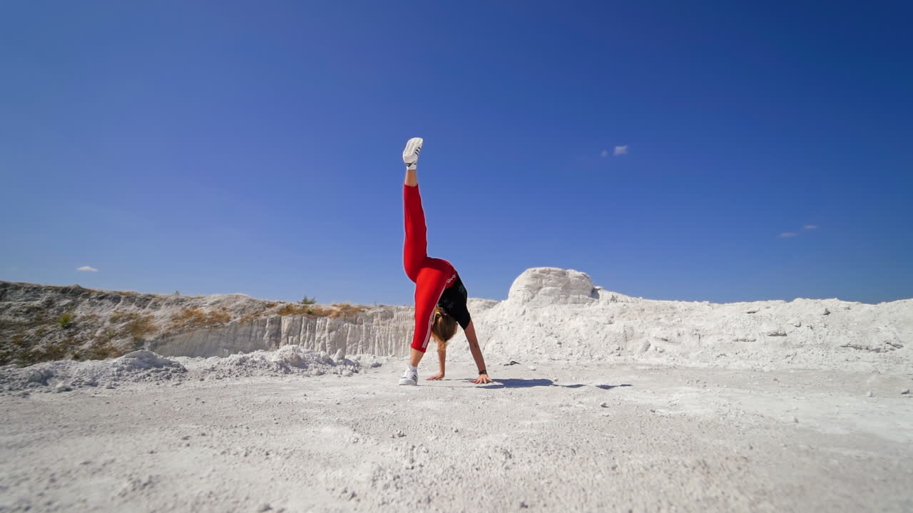 Woman performing parkour/acrobatic jump in quarry