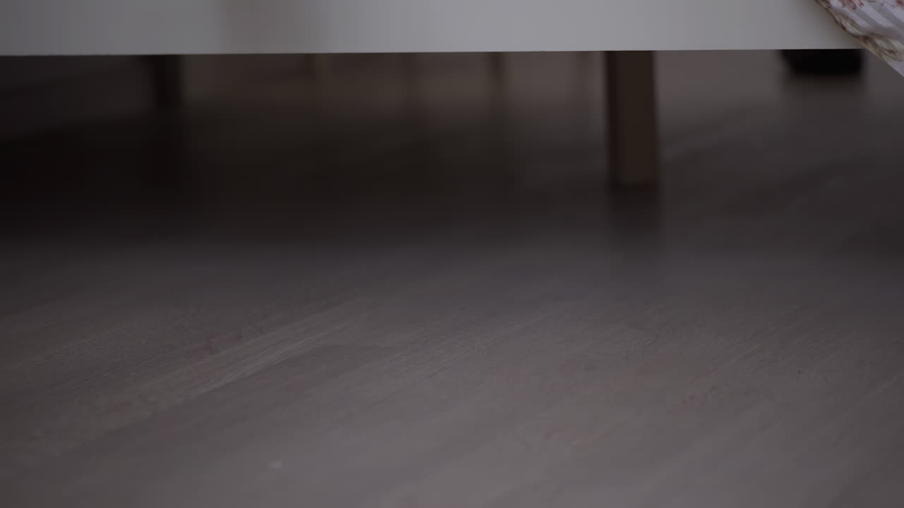 Woman's foot getting out of bed on the linoleum floor