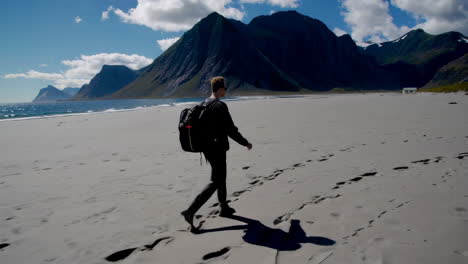 traveler walking on a scenic sandy beach with mountains