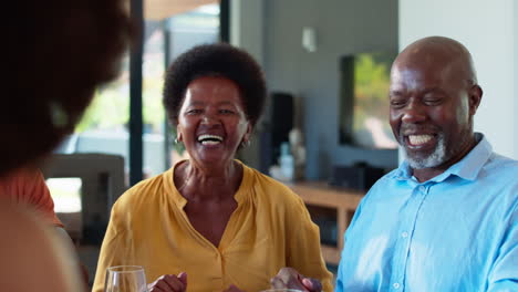 Family-Shot-With-Senior-Parents-And-Adult-Offspring-At-Breakfast-Around-Table-At-Home