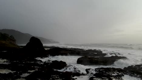 gliding across wave battered rocky oregon coast, storm clouds on the horizon, aerial