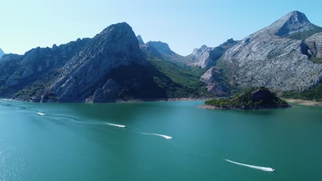 Drone-View-from-several-Jetski-on-Lake-Riaño-and-the-mountain-chain-background