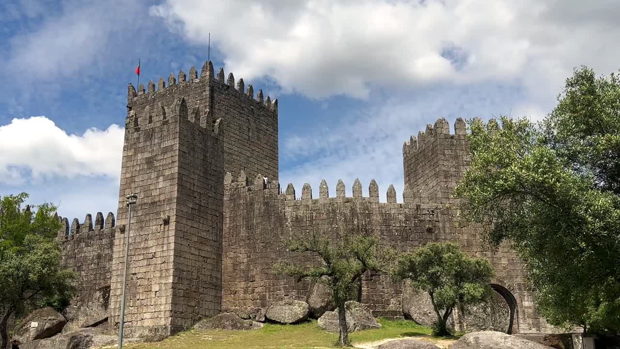 Panorama view of historic Castle in Guimar&atilde;es during cloudy day, Portugal - Slow motion wide shot of architecture