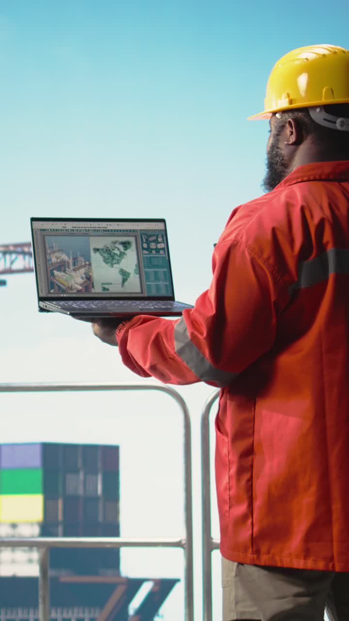 Vertical video Geologist on drilling barge deck studying maps to locate ...