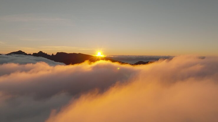 Vuelo de dron sobre las nubes durante un amanecer en Madeira, Portugal