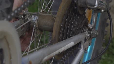 man tightens the bicycle wheel axle nut with a wrench