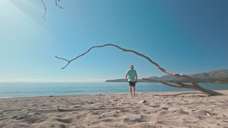 man explores deserted meditereanean greek beach in morning sun