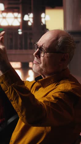 vertical video experienced man rehearsing a theatre script in a quiet library