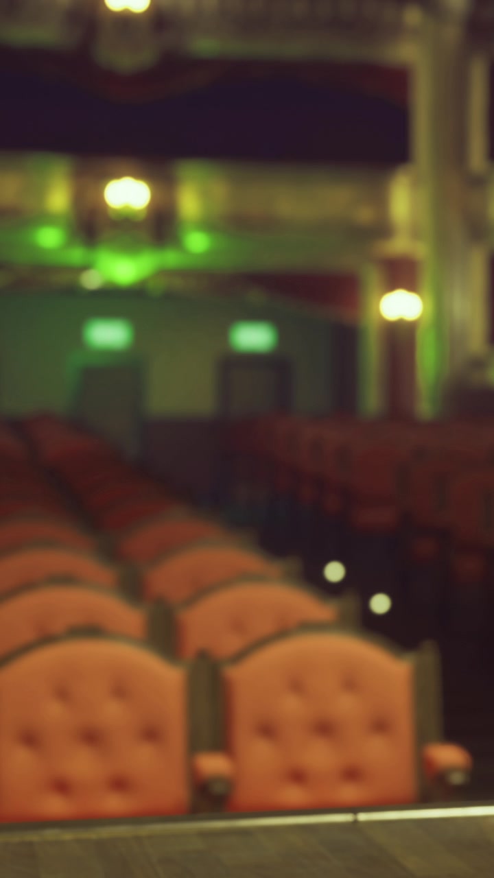 I posti sono disposti in un teatro con luci e spazio vuoto.