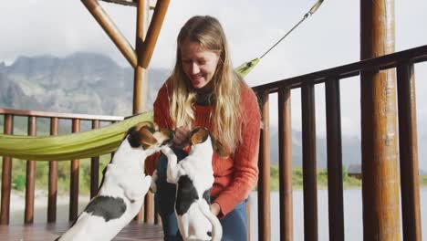 caucasian couple spending time at home together, playing with dogs