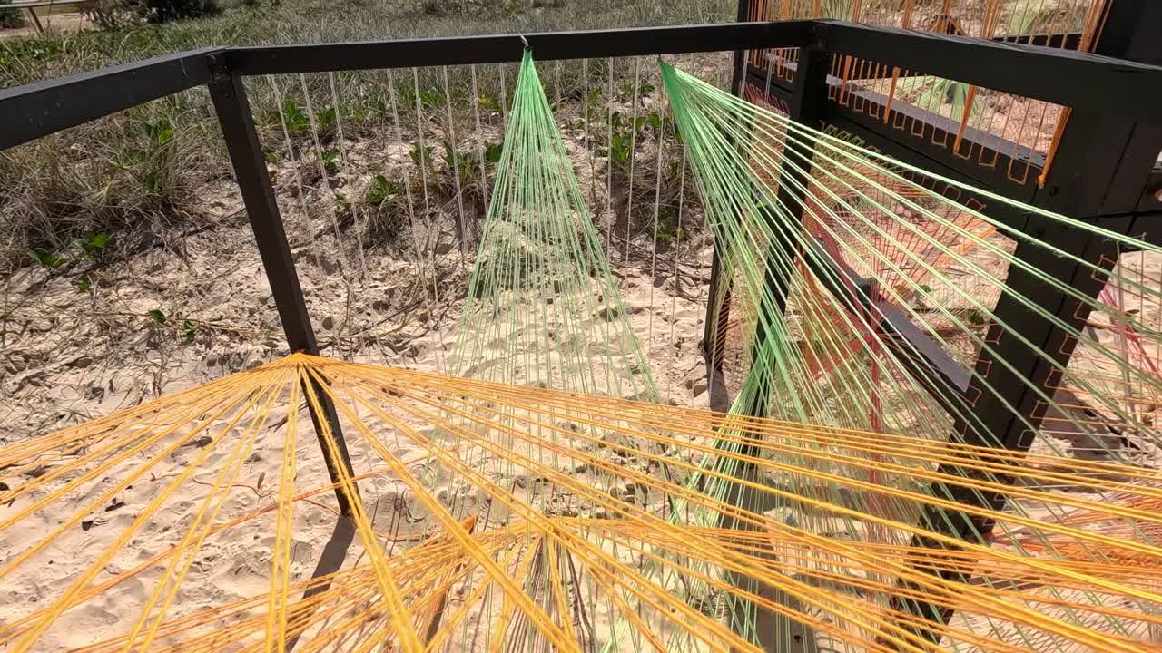 Vibrant string art cubes on sandy beach