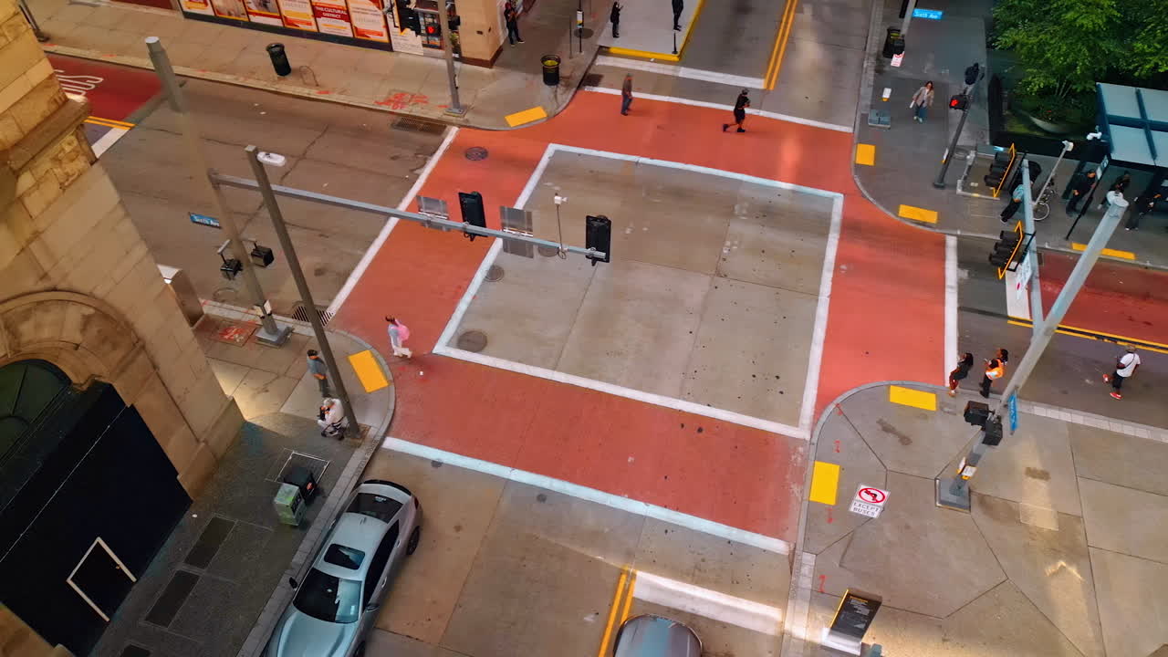 Pittsburgh, USA, 2 August 2025: Crossroads with colorful marking. People walk by the street and stand on the bus stop. Pittsburg, Pennsylvania, USA