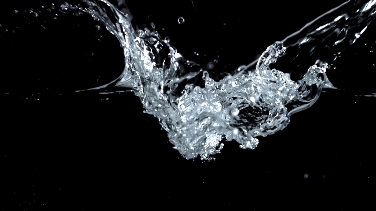 Klart vand sprøjter og bobler i slowmotion på sort baggrund