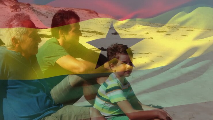 Drei Personen sitzen am Strand mit animierter ghanaischer Flaggenüberlagerung im Hintergrund.