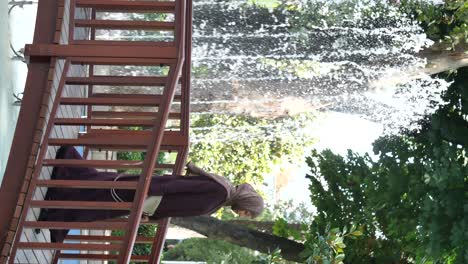 woman on a wooden bridge by a spraying fountain