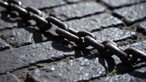 rusty chain on cobblestone pathway