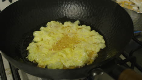 adding mixed eggs into big asian frying pan