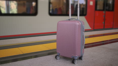 pink suitcase at train station