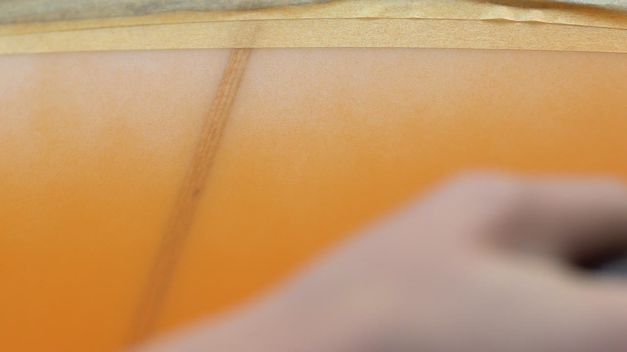 Close-up of Orange Spray Paint on Wood with Masking Tape