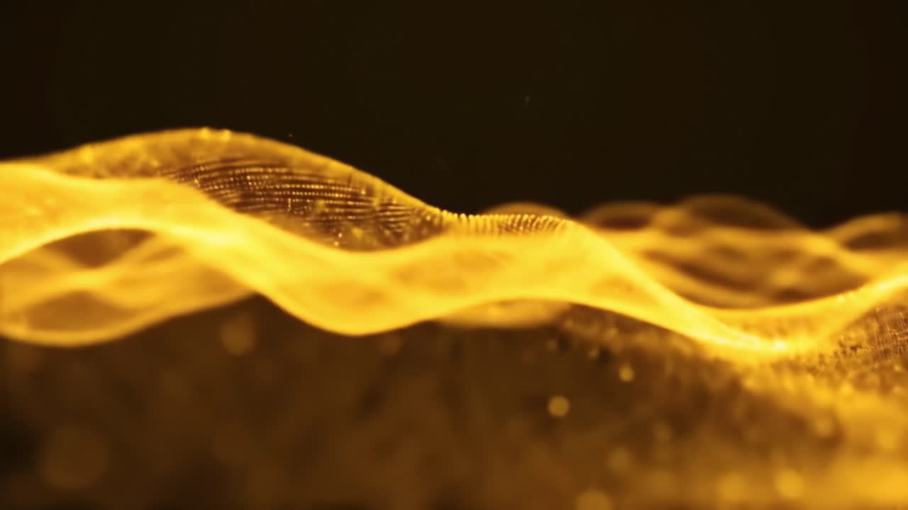 Golden waves ripple elegantly against a dark backdrop, creating a tranquil and mesmerizing visual experience. The fluid motion captivates attention, inviting viewers to reflect and relax.