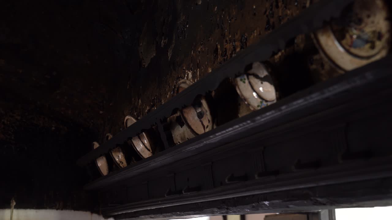 closeup de cuencos de cerámica en un estante de madera en un entorno de cocina rústica con iluminación cálida