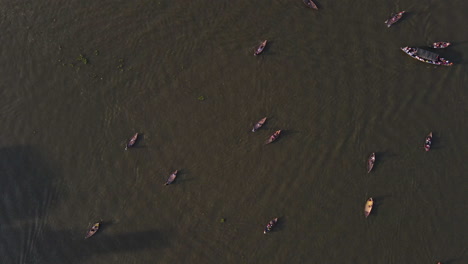 Barcos-De-Pasajeros-De-Madera-Para-Cruzar-El-Río-En-El-Río-Buriganga---Toma-Aérea-Ascendente-De-Drones-De-Arriba-Hacia-Abajo